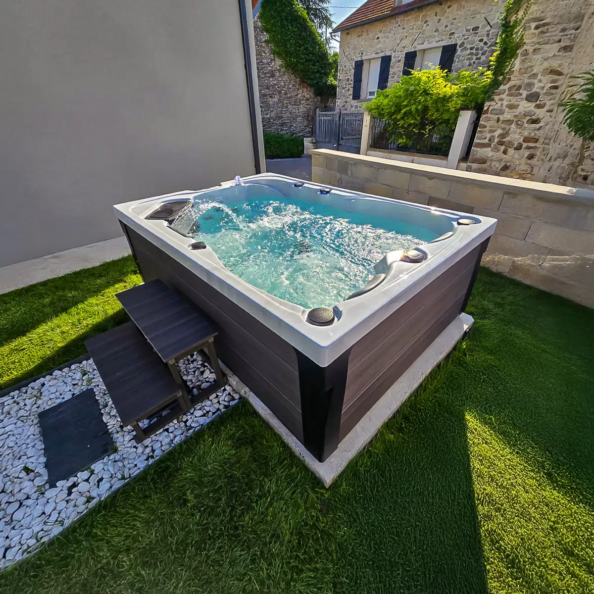 Bahamas – Spa 3 places Vendom installé dans un jardin, disponible chez Only Spa - White Marble - Vue de face