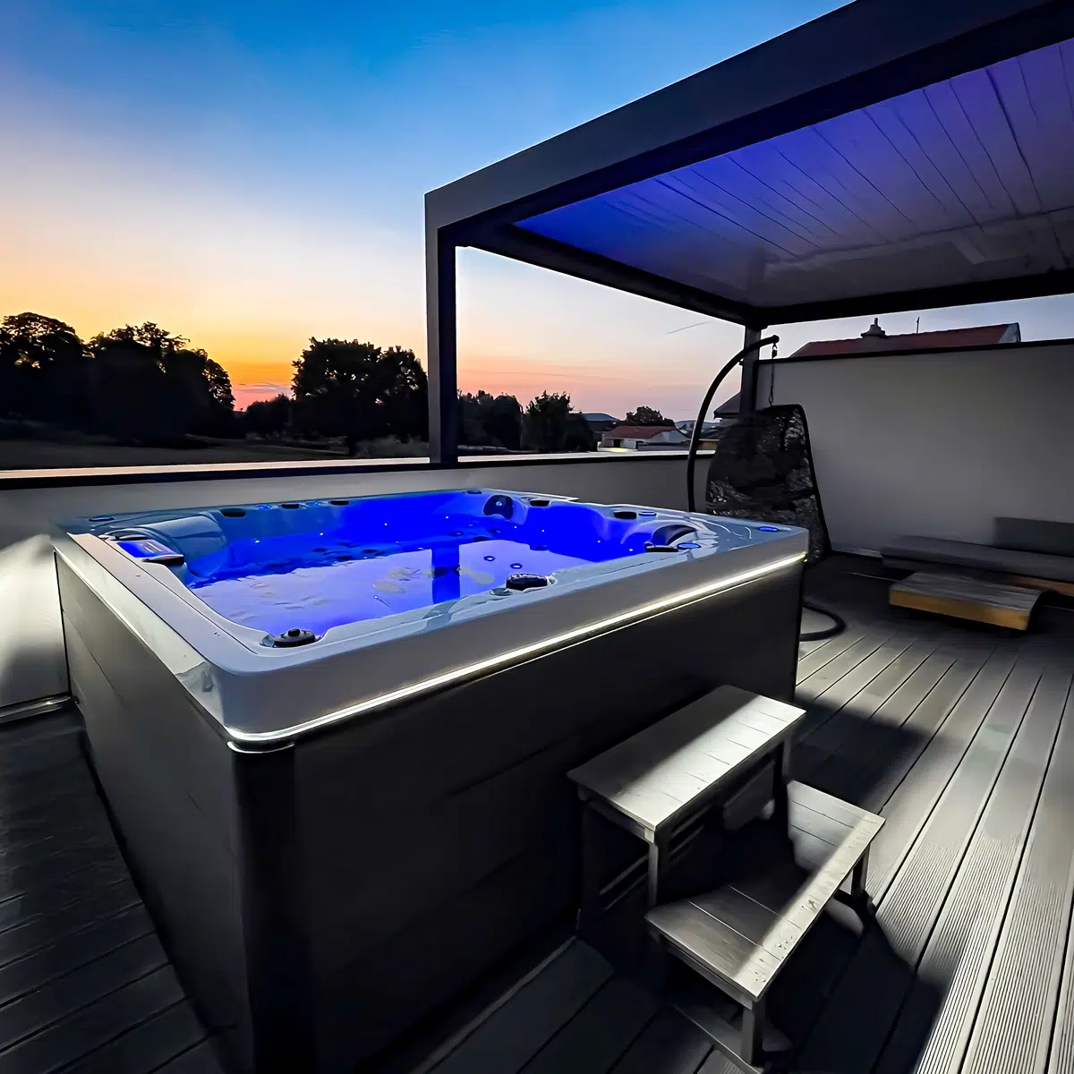 Spa Vendom Polynésie 5 places illuminé en bleu au coucher du soleil sur une terrasse moderne