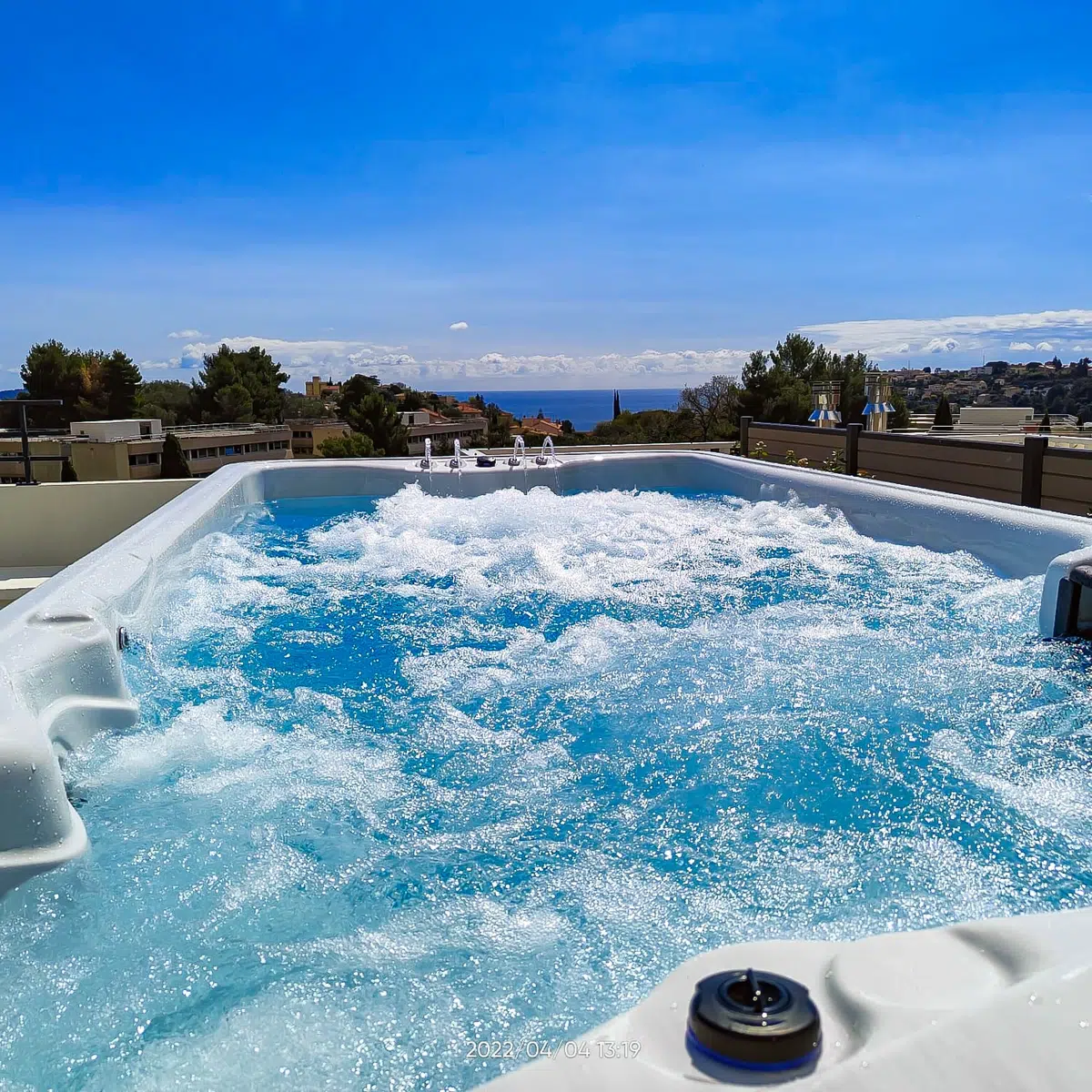 Vue rapprochée des jets en fonctionnement du spa de nage monobassin Tilos de la marque Vendom, installé dans un jardin moderne